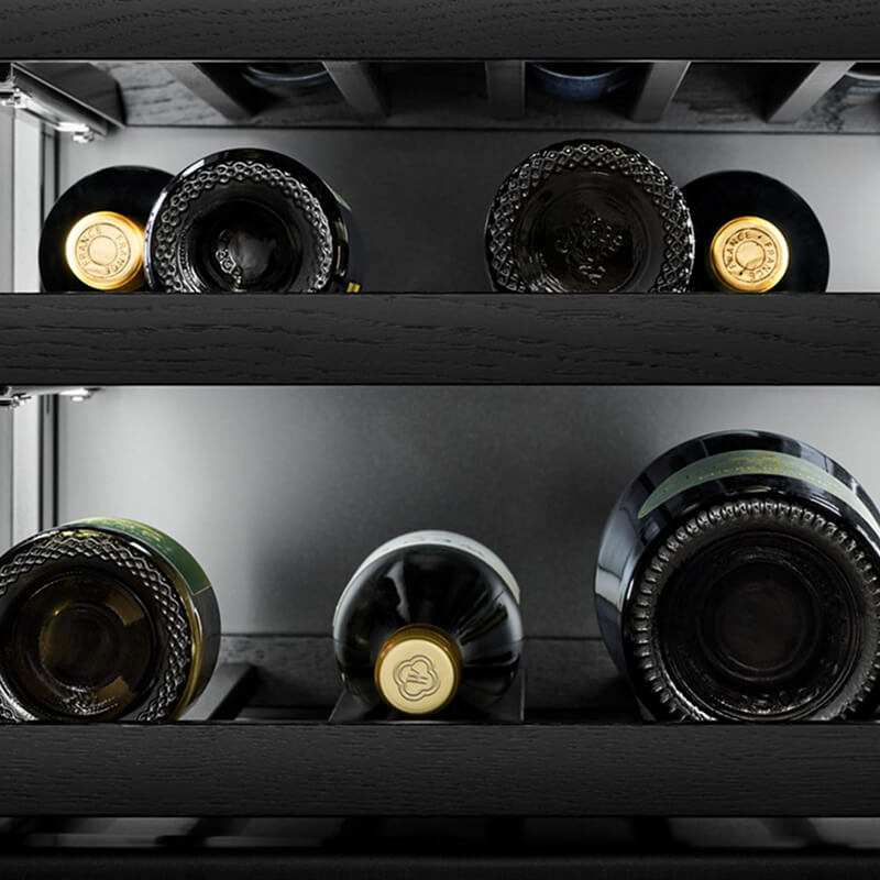 Wine bottles stored in a built-in wine refrigerator.