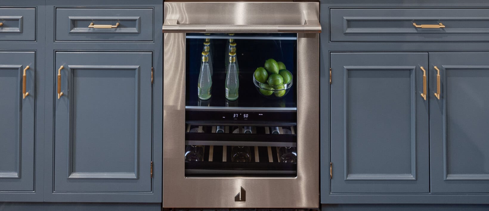 A built-in home bar with blue cabinets and an undercounter beverage center.