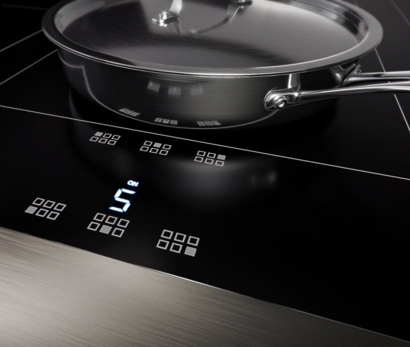 An induction cooktop with stainless steel cookware.
