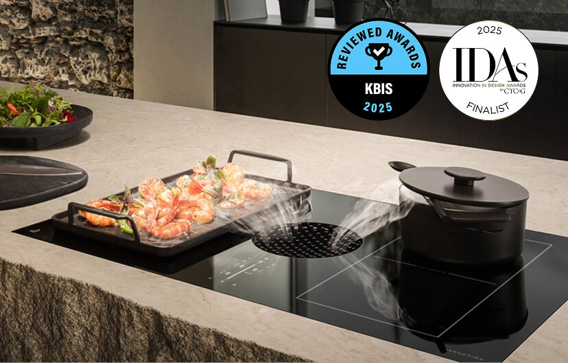 Two dishes with steam cooking on a JennAir® Induction Downdraft Cooktop.