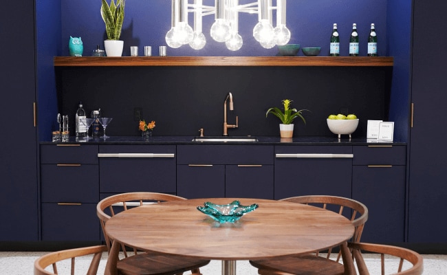 A small kitchen with navy blue cabinets. 