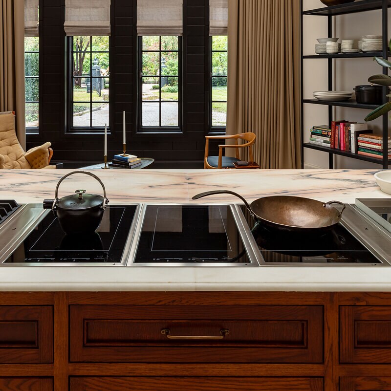 Compact cooktops and a custom induction wok on a kitchen island.