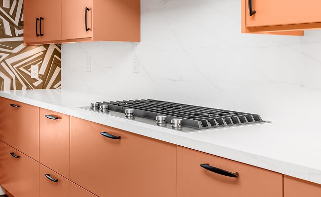 A stainless steel gas cooktop on a kitchen island.