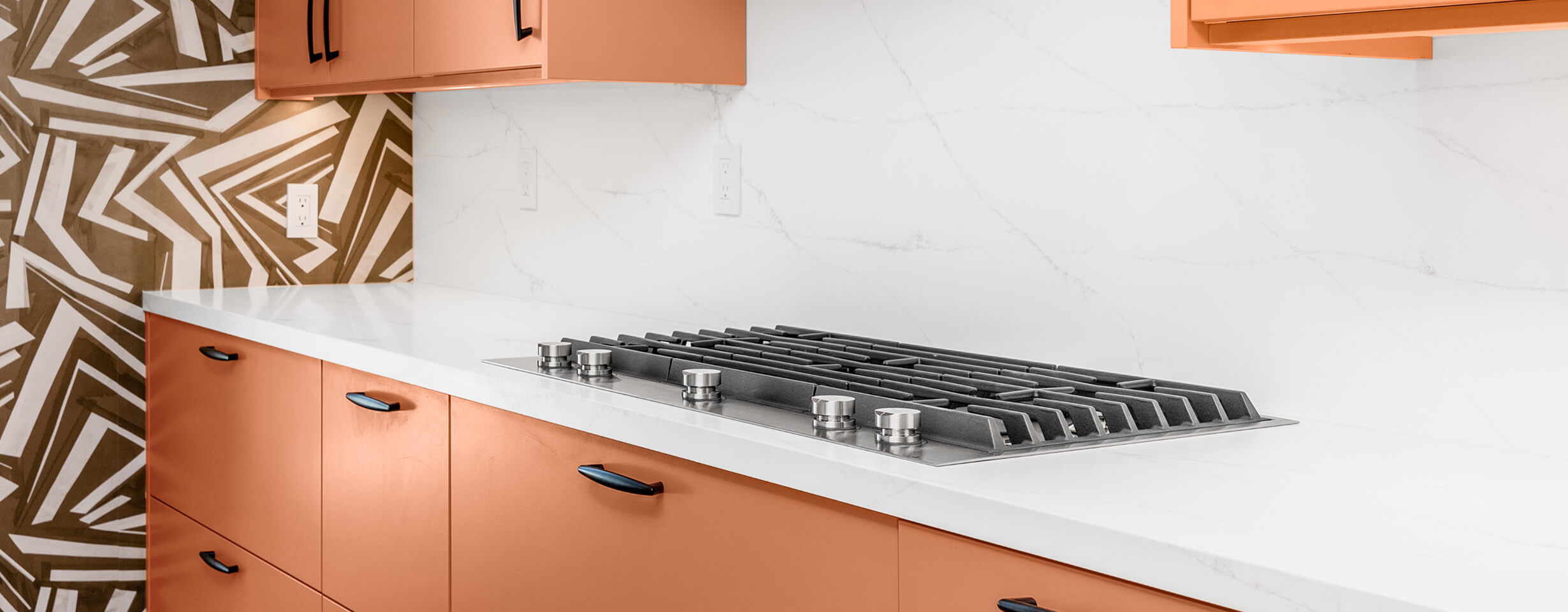 A stainless steel gas cooktop on a kitchen island.