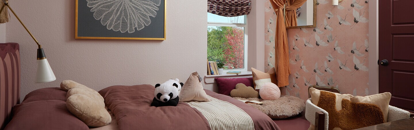 A bright bedroom with a plush panda and other pillows on the bed. A bright bedroom with a plush panda and other pillows on the bed.