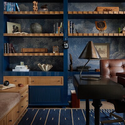 A blue built-in bookcase with brown accents in an office.