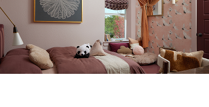 A bright bedroom with a plush panda and other pillows on the bed. A bright bedroom with a plush panda and other pillows on the bed.