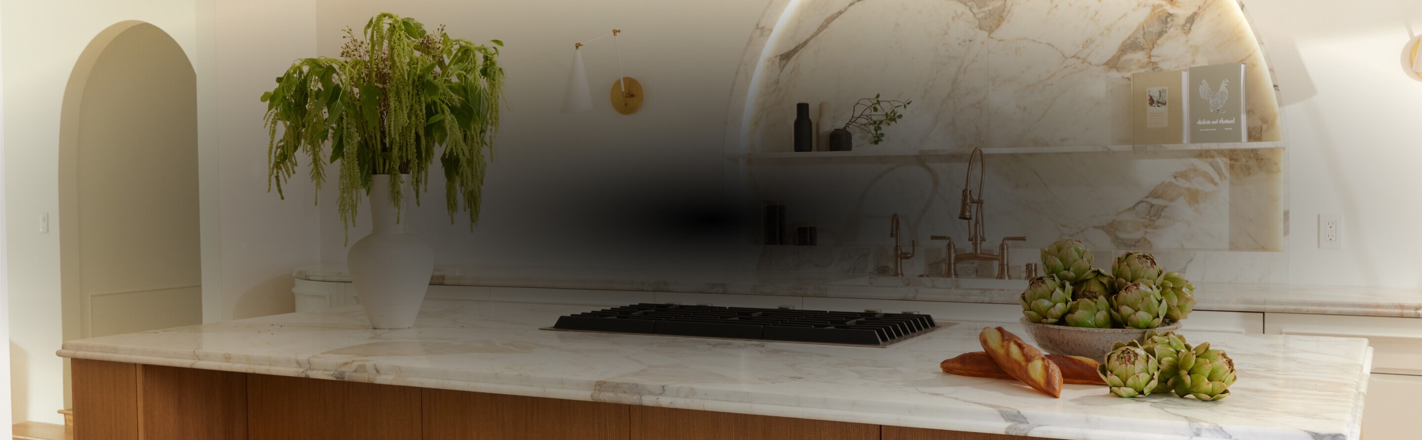  A white and light wood kitchen with a marble backsplash, designed by Nina Takesh.