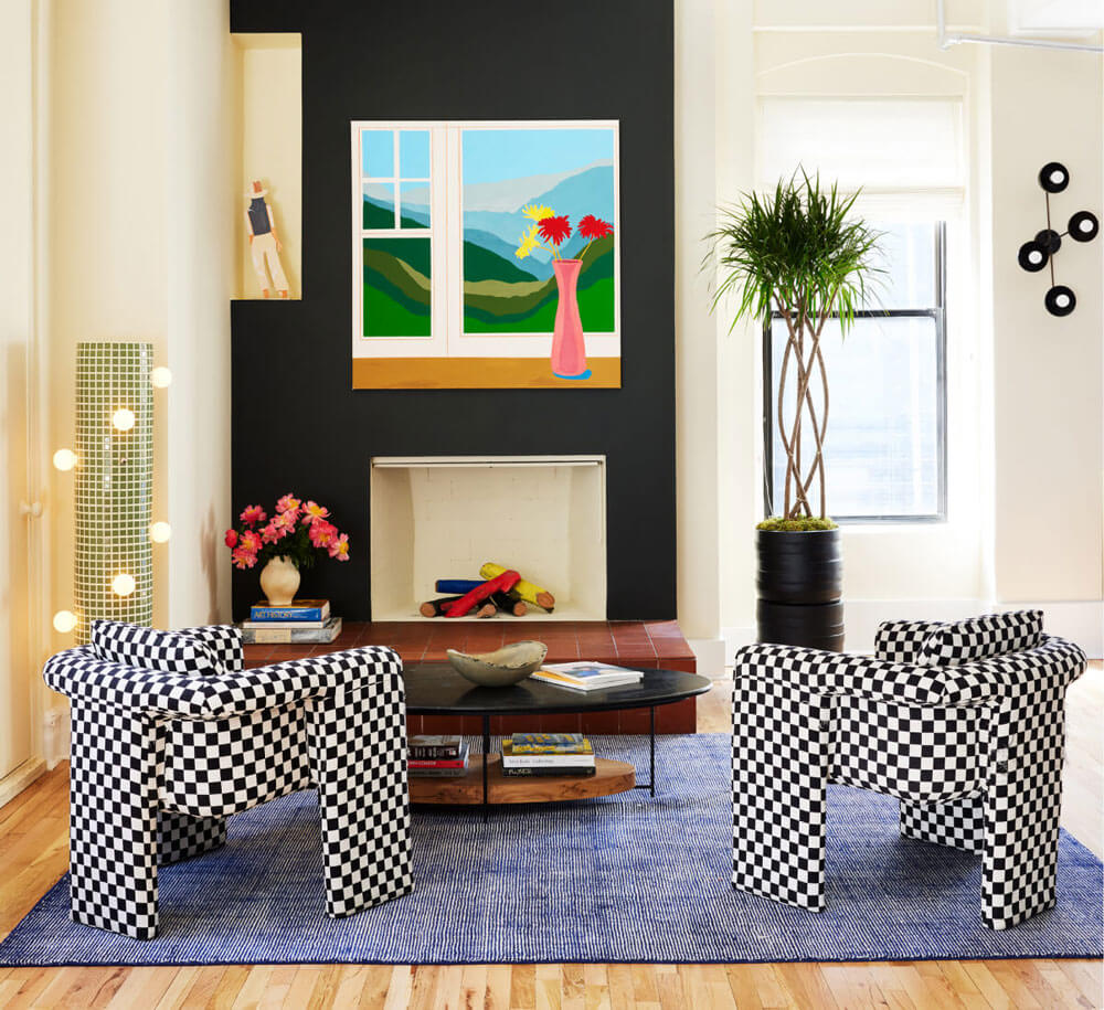 A small living room with a fireplace and checkerboard-patterned chairs. A small living room with a fireplace and checkerboard-patterned chairs.