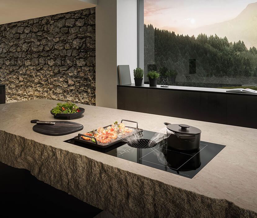 A quiet induction downdraft cooktop ventilates cooking fumes in a luxury kitchen