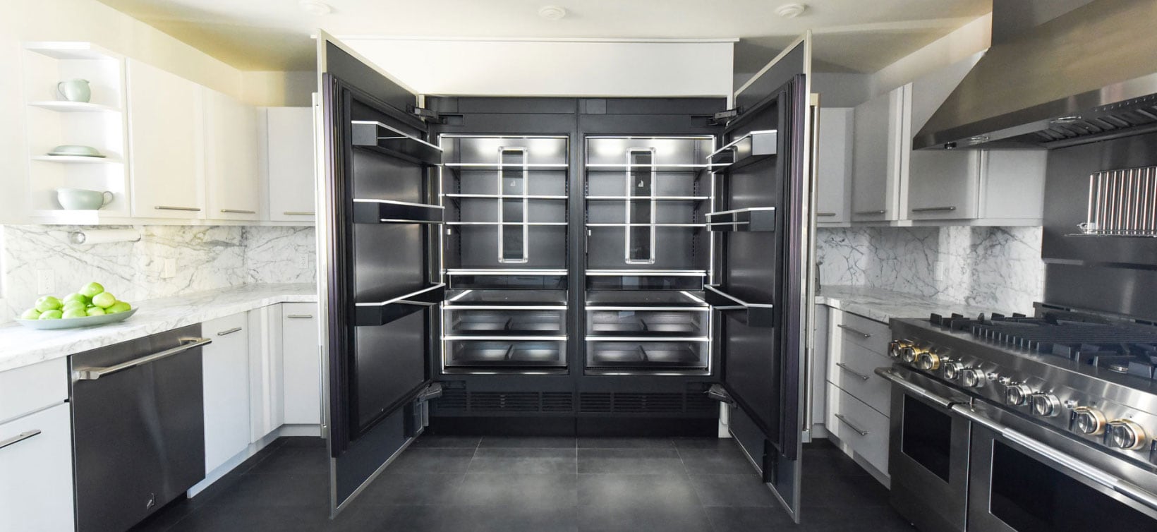 A bold, modern kitchen with an open JennAir® Refrigerator showcasing the Daring Obsidian Interior. A bold, modern kitchen with an open JennAir® Refrigerator showcasing the Daring Obsidian Interior.