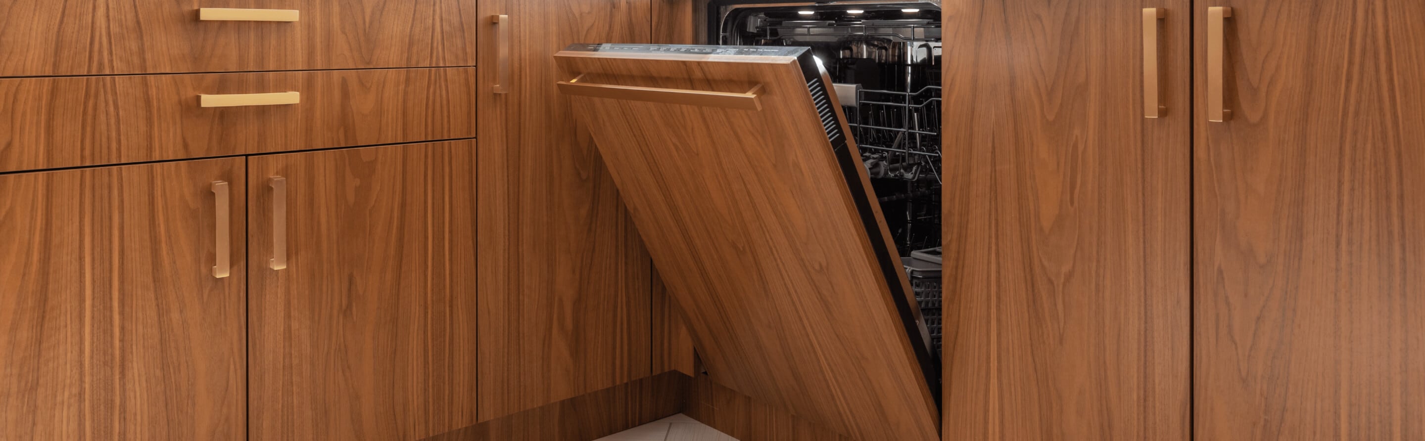 An open luxury, quiet dishwasher with brown cabinets