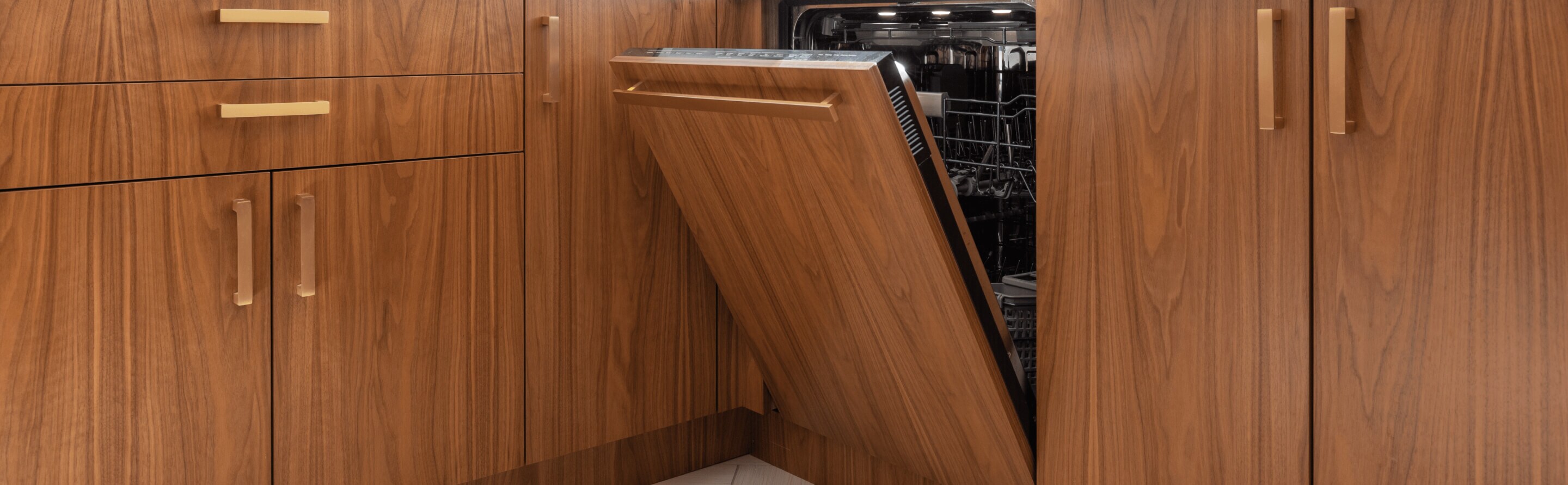 An open luxury, quiet dishwasher with brown cabinets
