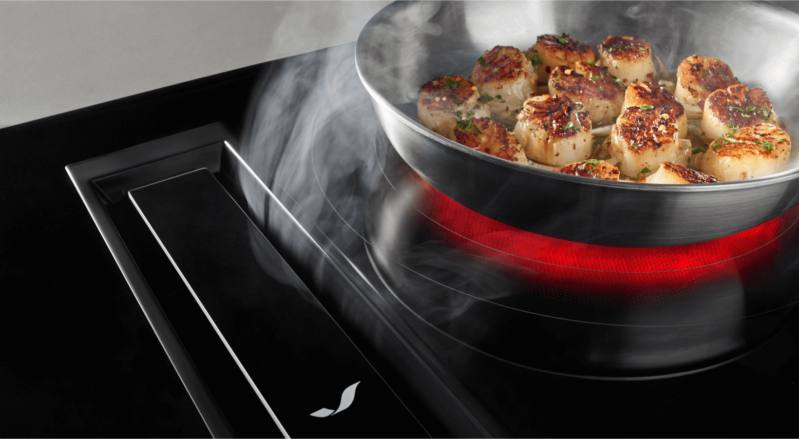 Scallops cooking on an electric cooktop with downdraft ventilation