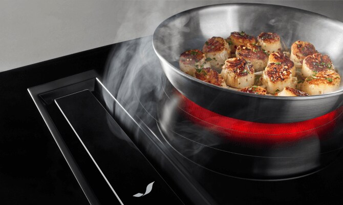 Scallops cooking on an electric cooktop with downdraft ventilation