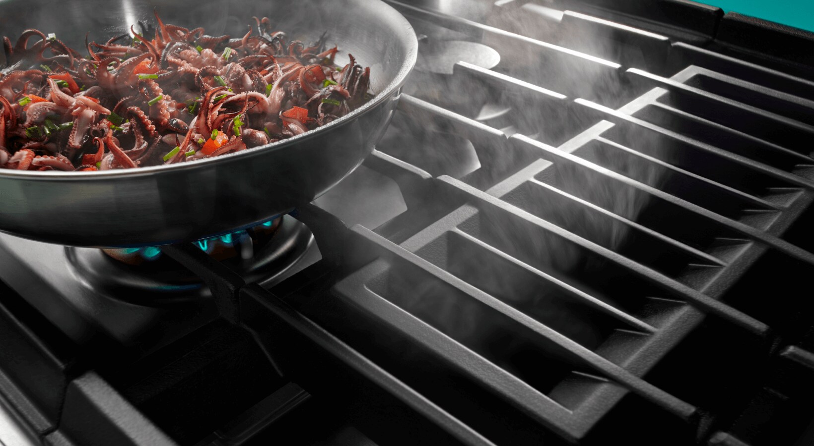 Food cooking on a gas cooktop with downdraft ventilation