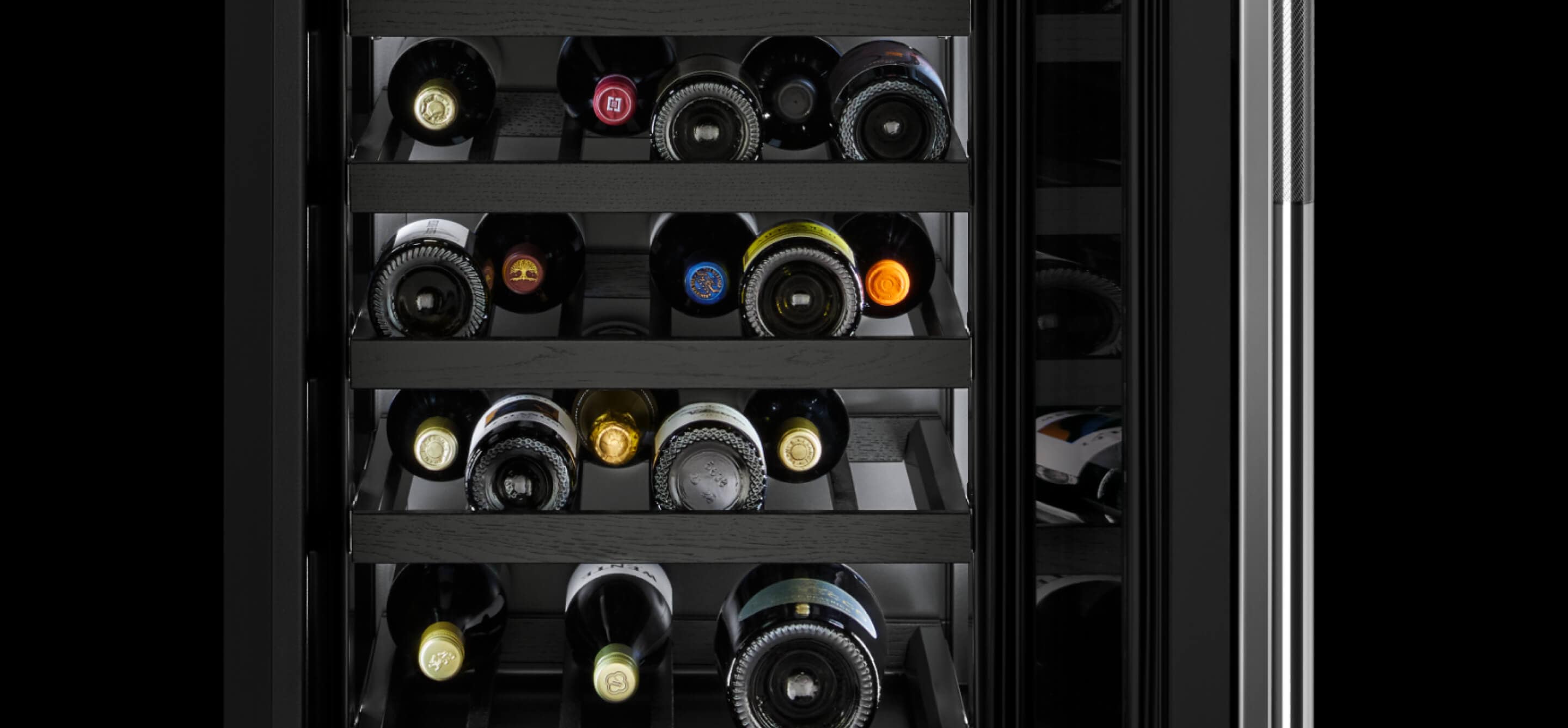 Interior of JennAir® Wine Refrigerator filled with wine bottles.