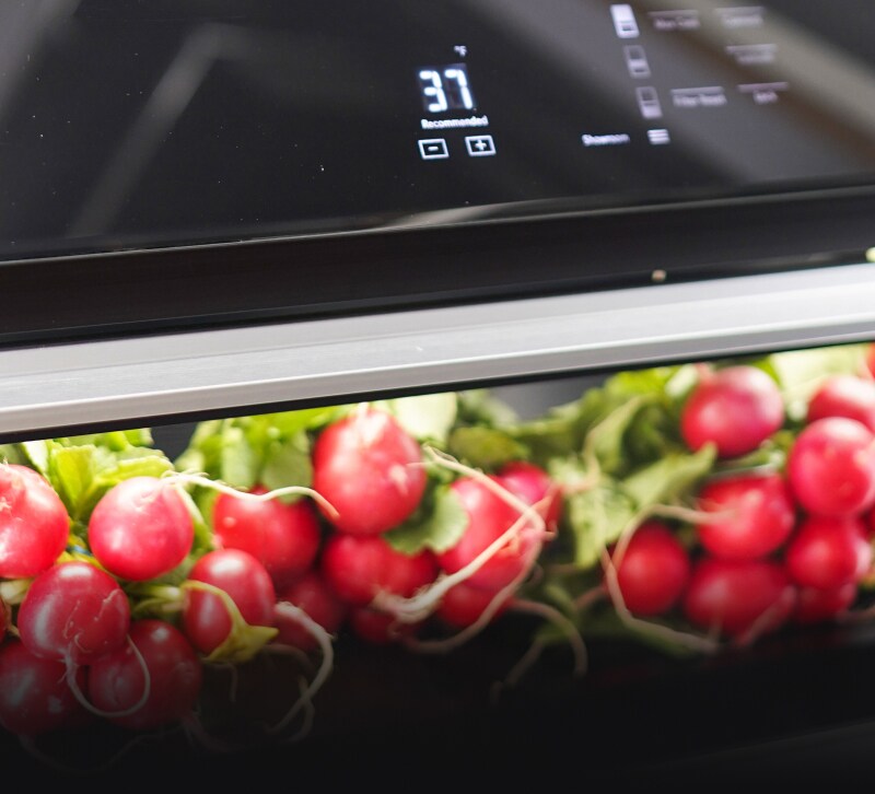 Whole radishes inside of a Column Refrigerator drawer.