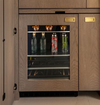 A close up of a JennAir® Beverage Center fitted with custom wooden panels.