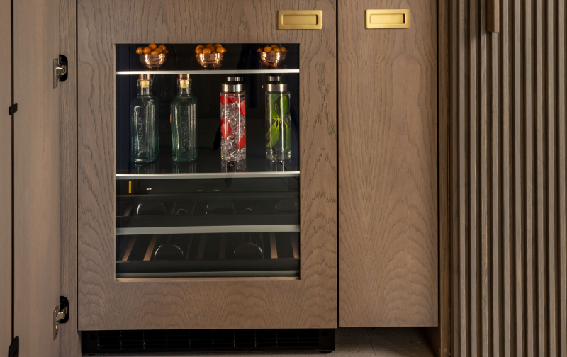 A close up of a JennAir® Beverage Center fitted with custom wooden panels.