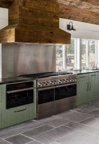 Another view of the kitchen, featuring a wall oven and range.