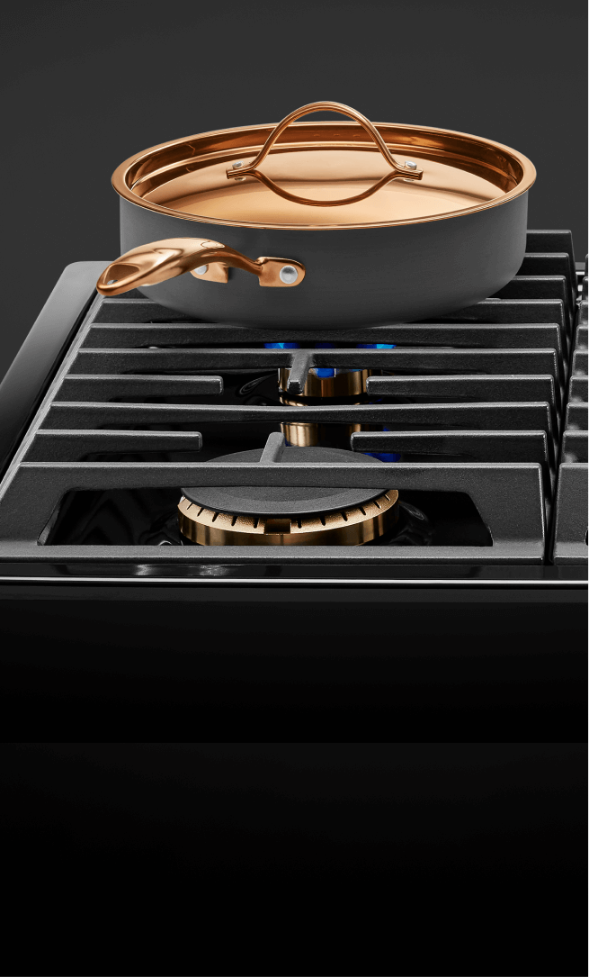 A frying pan and pot on a gas cooktop.