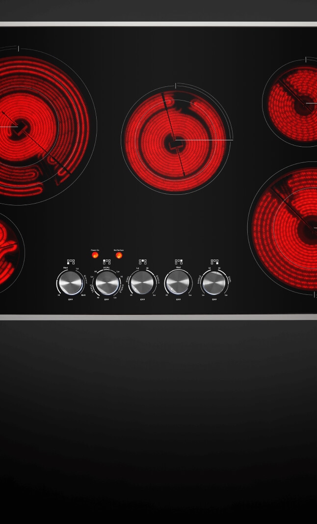 Top-down view of an electric radiant cooktop with the elements glowing red.