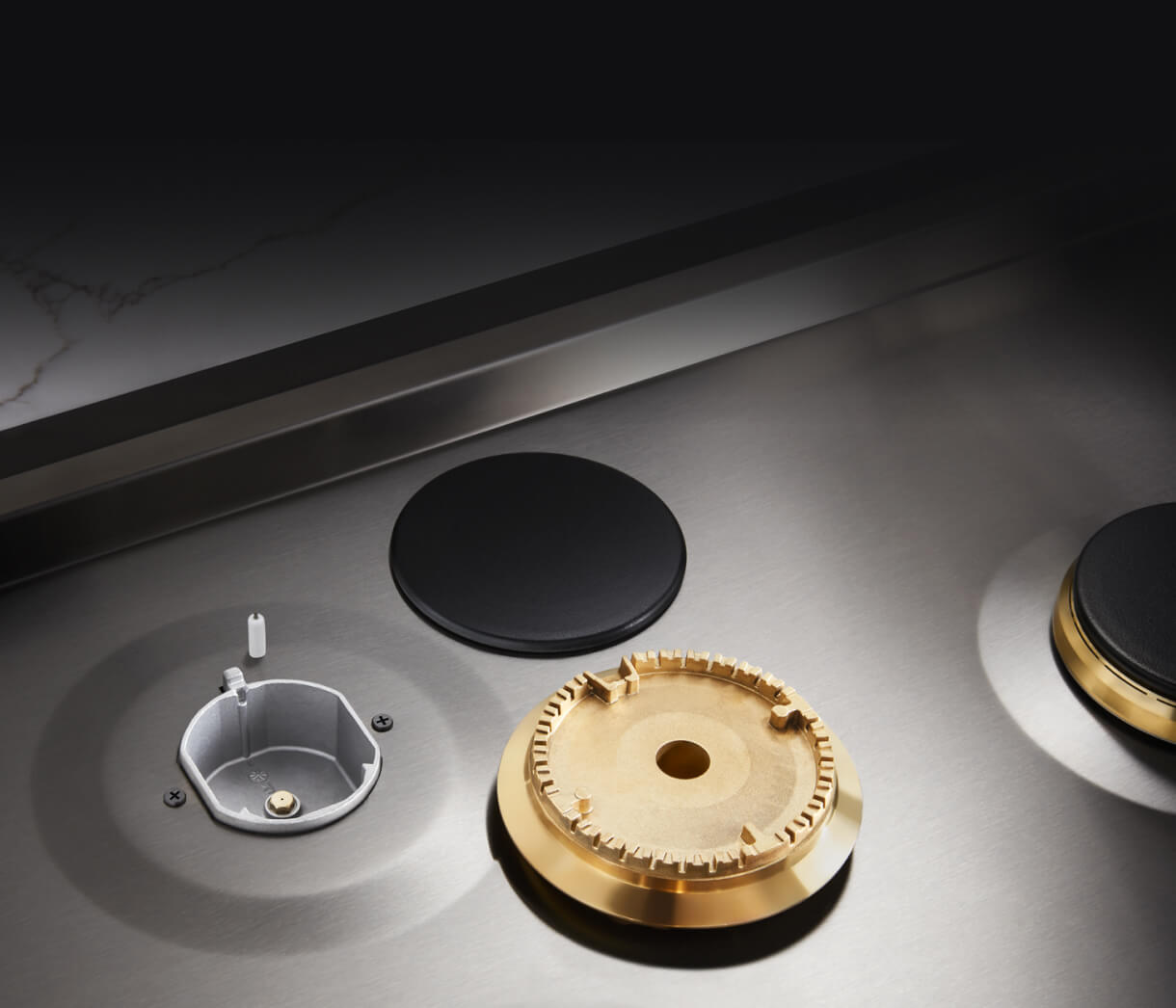 Closeup of the brass burner and cap removed from the cooktop.