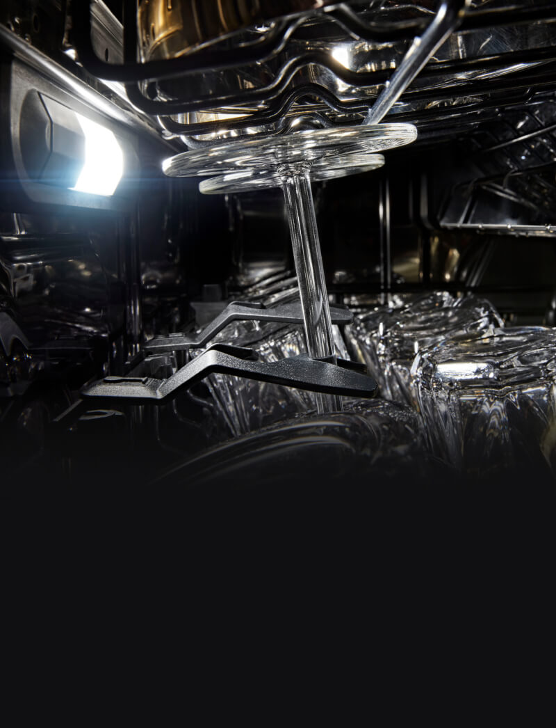 Closeup of wine glasses loaded on a dishwasher rack.