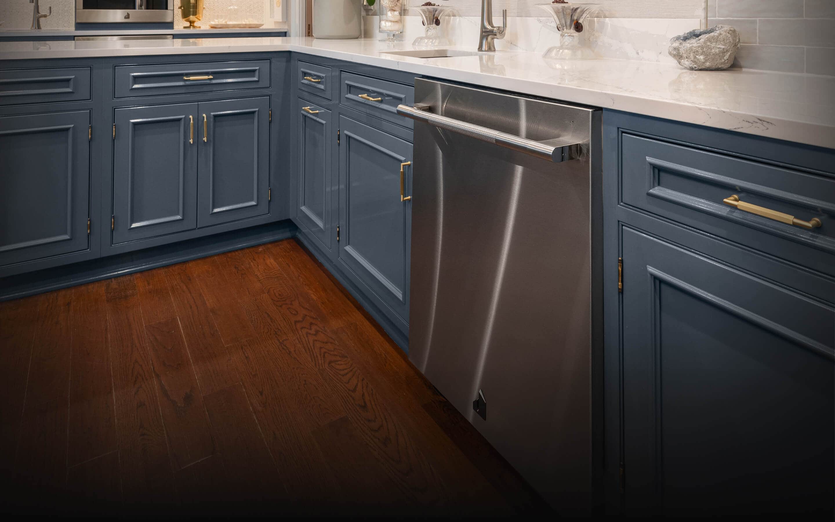 A JennAir® RISE™ Dishwasher in a kitchen with blue cabinets.