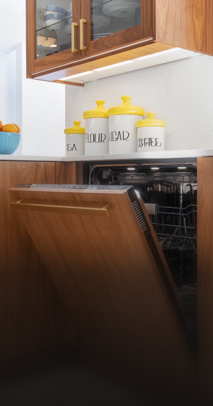 A JennAir® Panel-Ready Dishwasher in a kitchen with retro wooden cabinets.
