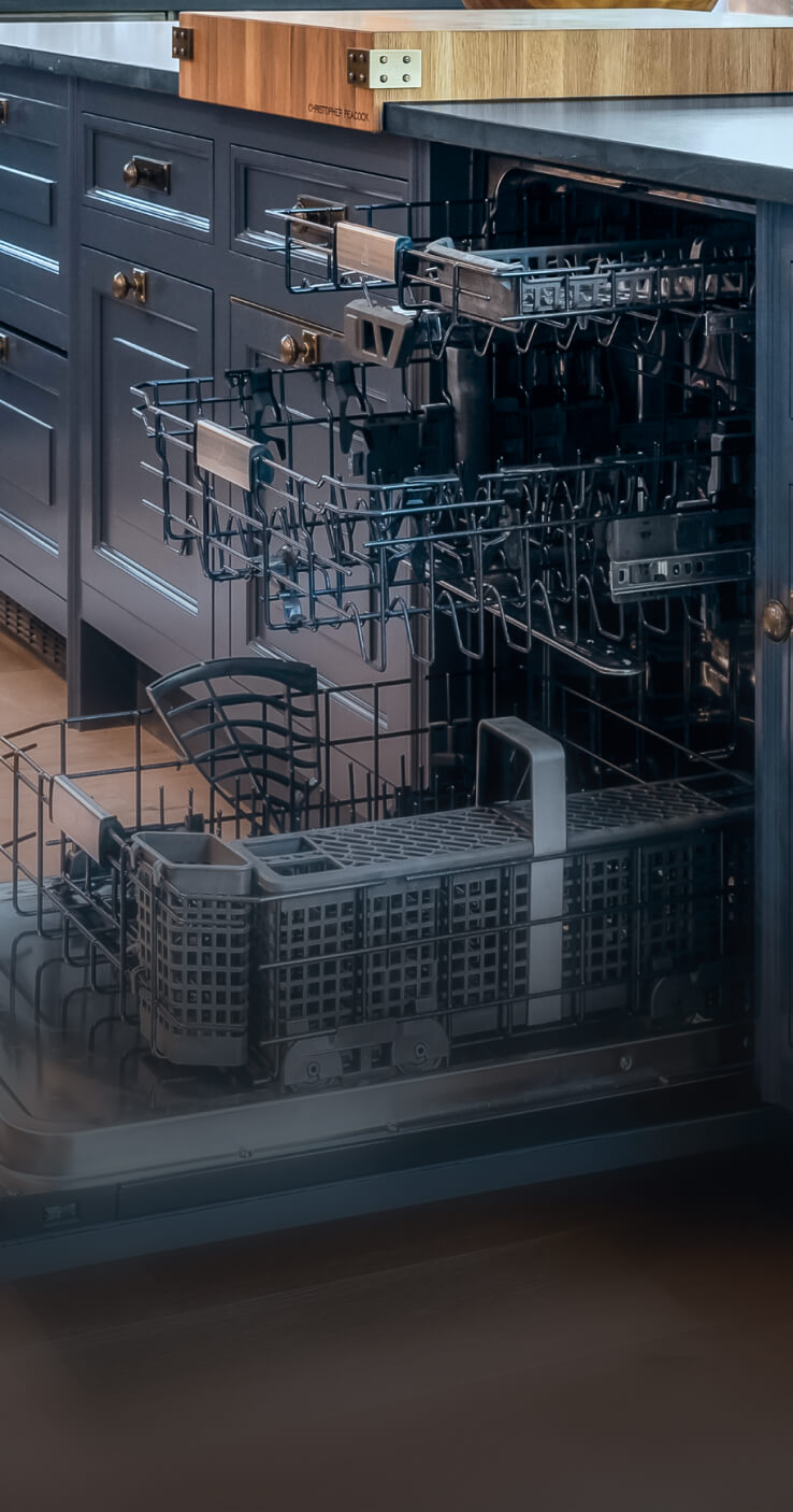 An open JennAir® Panel-Ready Dishwasher in a kitchen with blue cabinets.