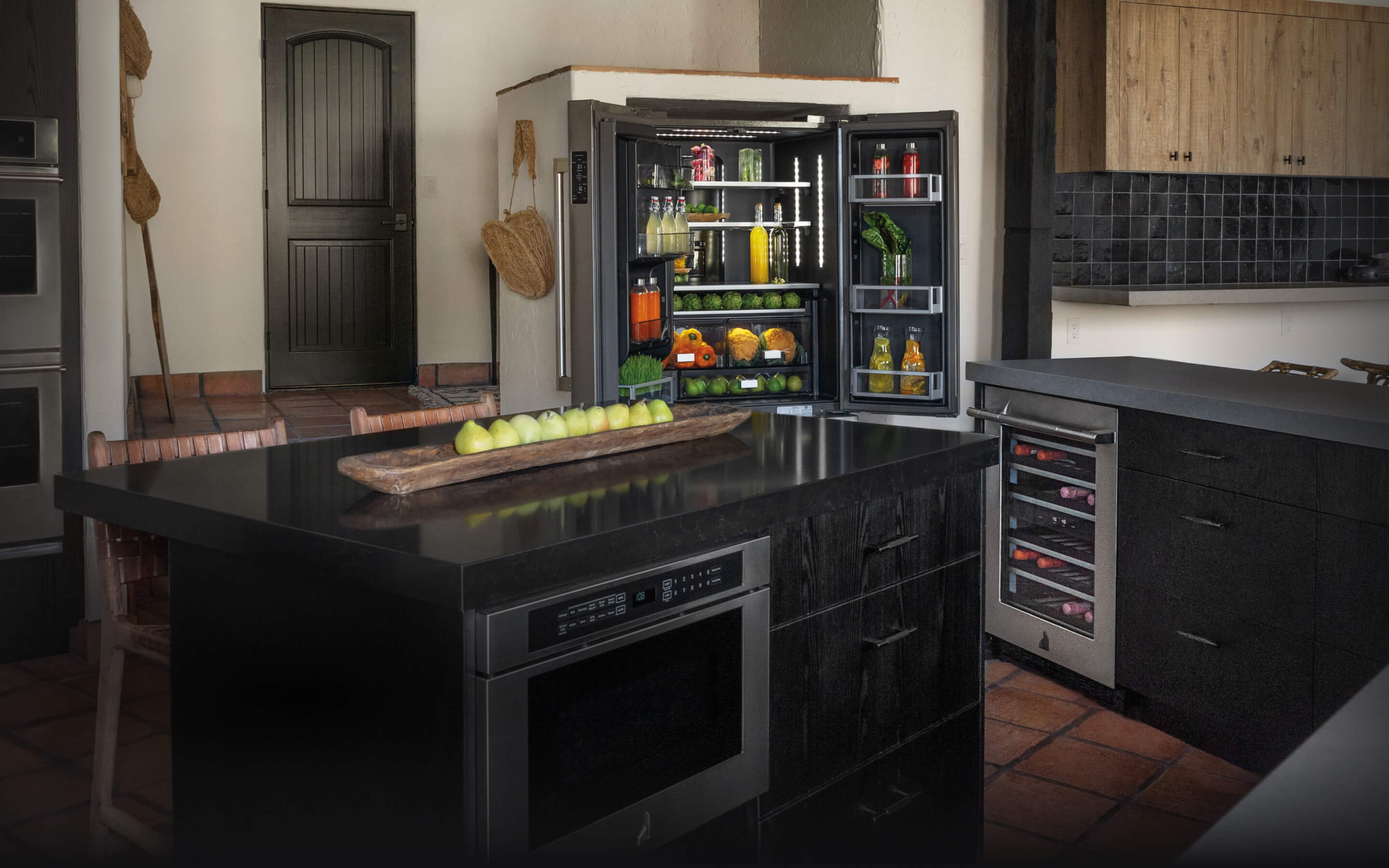A kitchen featuring an open and stocked JennAir® French Door Freestanding Refrigerator. A kitchen featuring an open and stocked JennAir® French Door Freestanding Refrigerator.