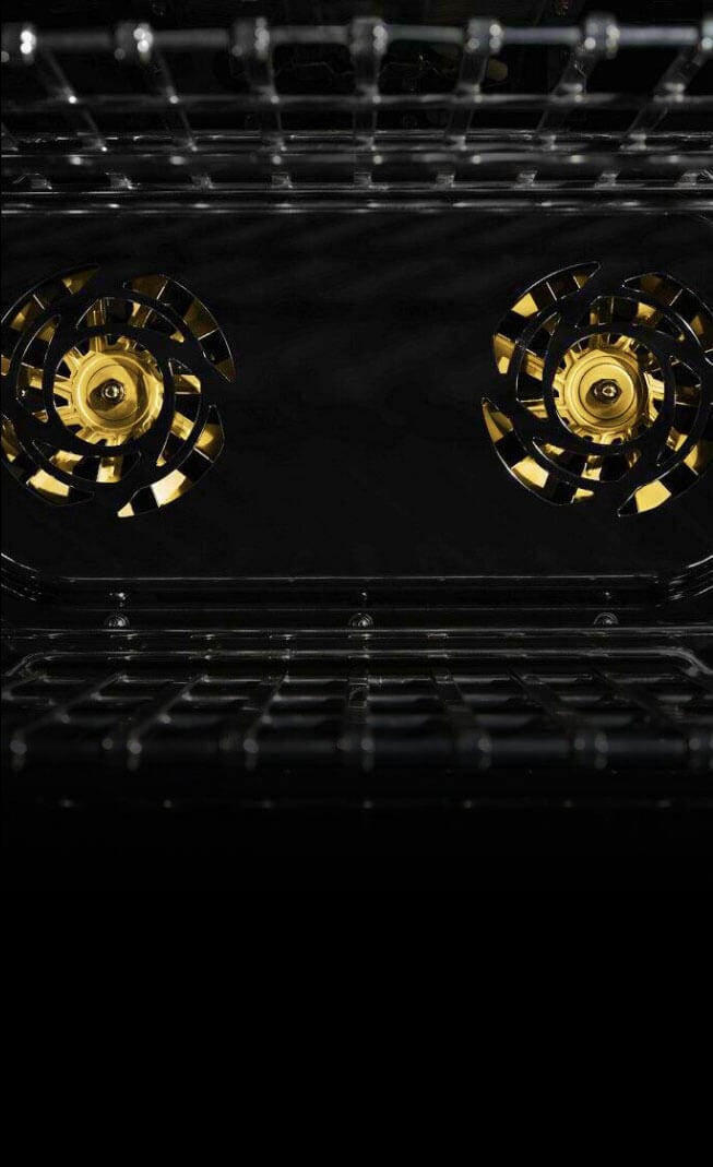 The interior of a JennAir® Professional-Style Range, with two brass fans.