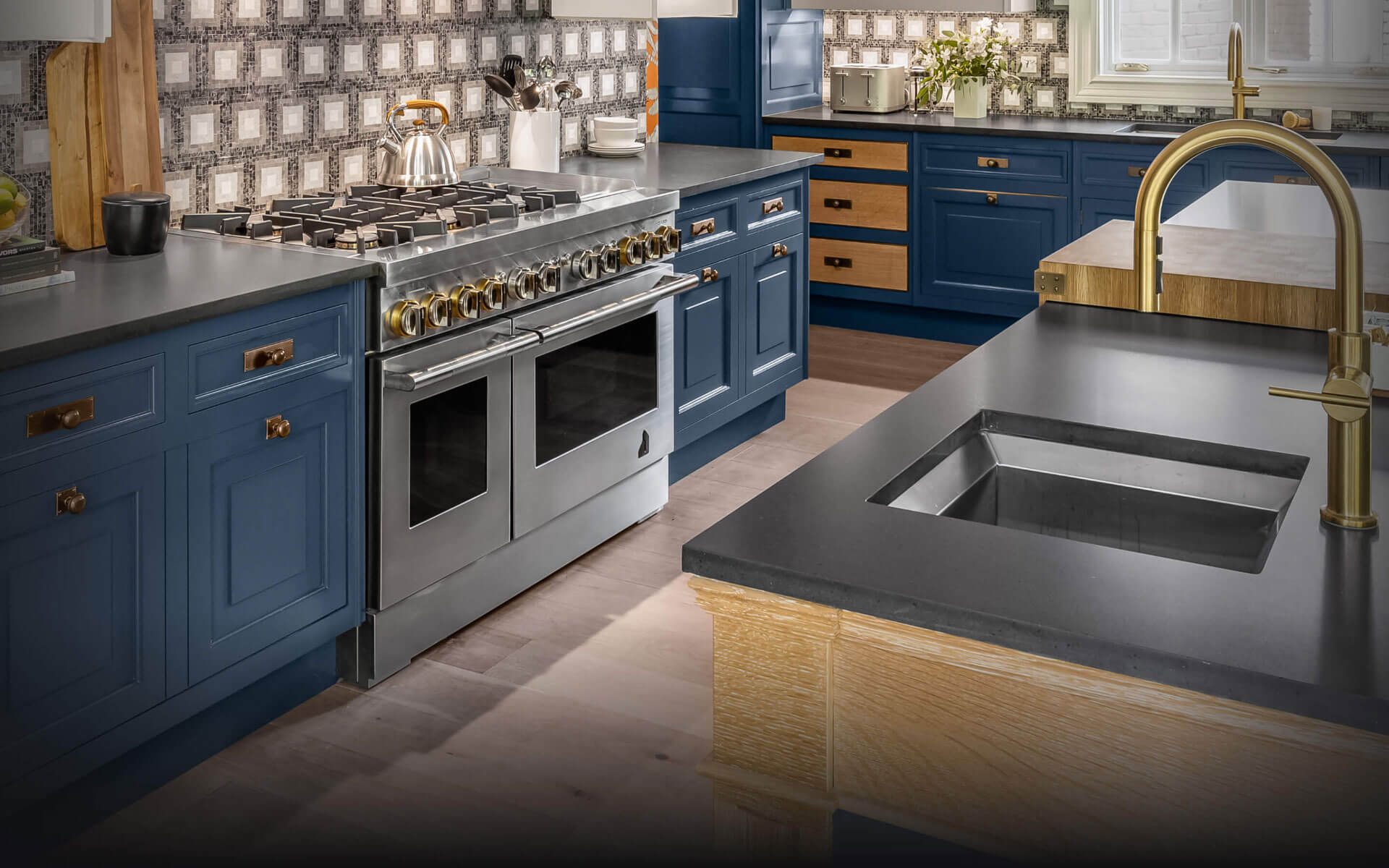 A JennAir® RISE™ Dual-Fuel Range in a blue luxury kitchen.