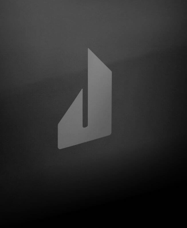 The screened Defiant J badge on the glass front of a NOIR™ Professional-Style Range.