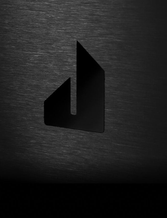 The screened Defiant J badge on the glass front of a NOIR™ Rangetop.