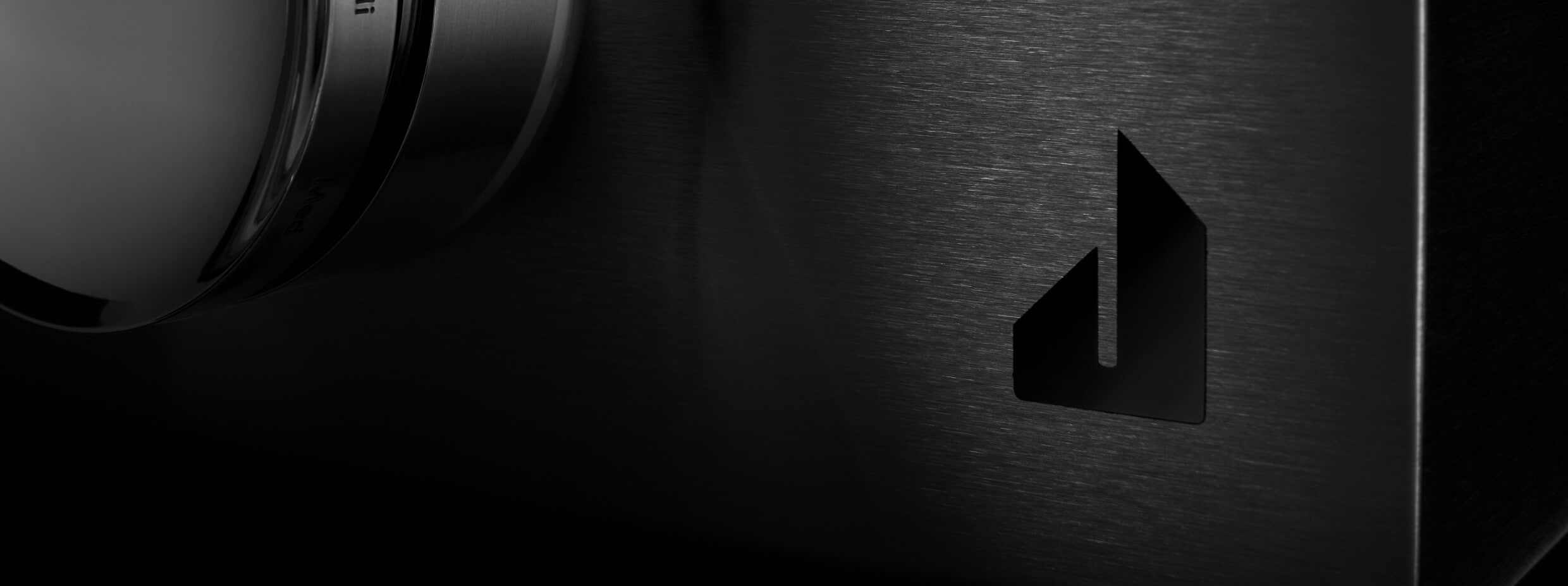 The screened Defiant J badge on the glass front of a NOIR™ Rangetop.