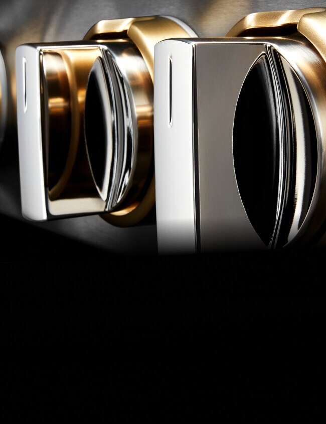 Closeup of the knobs of a JennAir® RISE™ Design Expression Rangetop, showing the brass details.