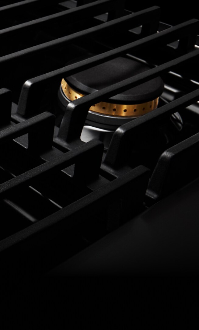 Closeup of the cast iron grates on a gas rangetop.