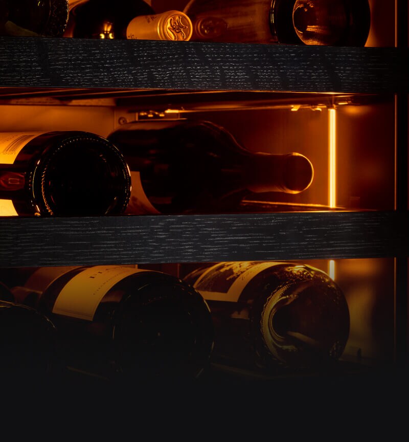 The interior of a wine column bathed in amber colored lighting.
