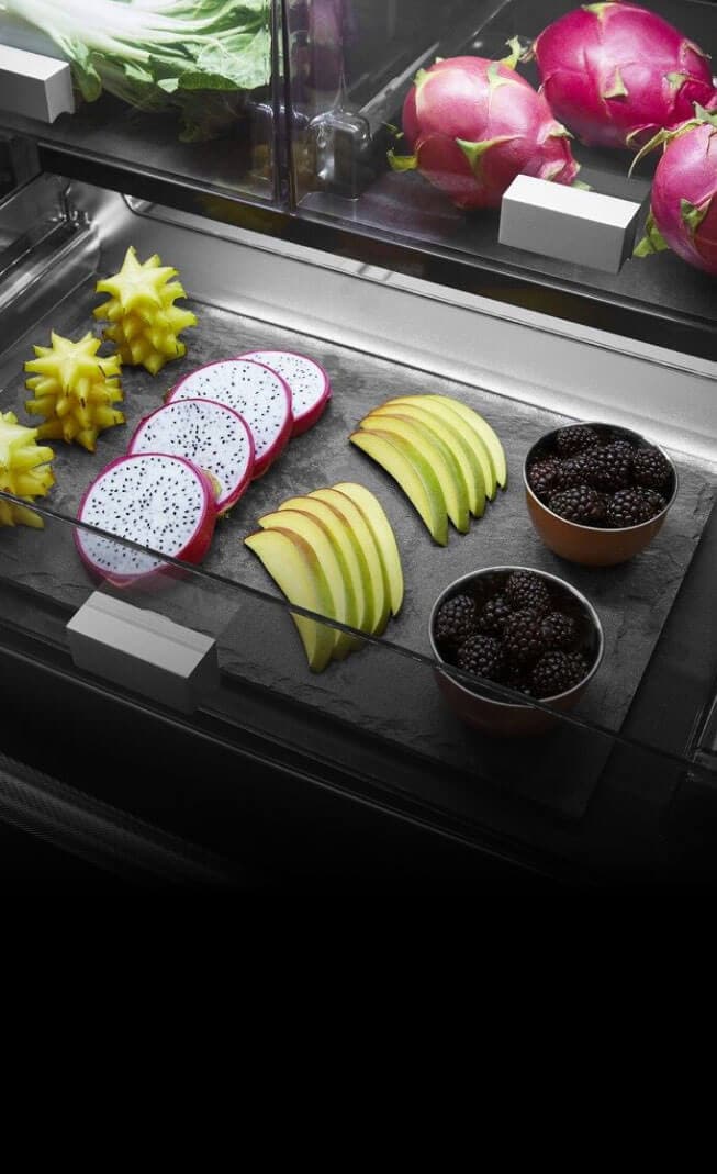 The interior of a full-width drawer filled with various fruits.
