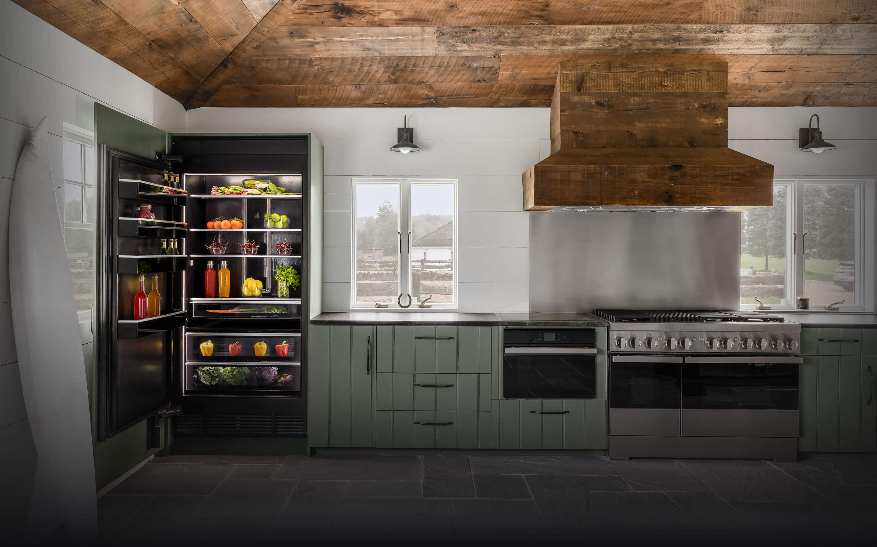 A soft green kitchen fitted with panel ready and NOIR™ appliances.