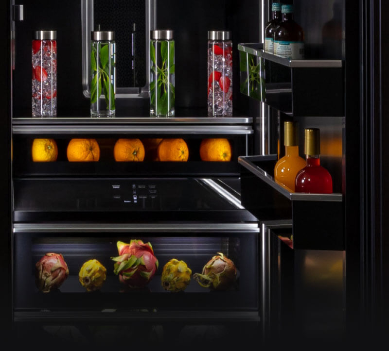 The interior of a refrigerator filled with various fruits, vegetables and herbs.
