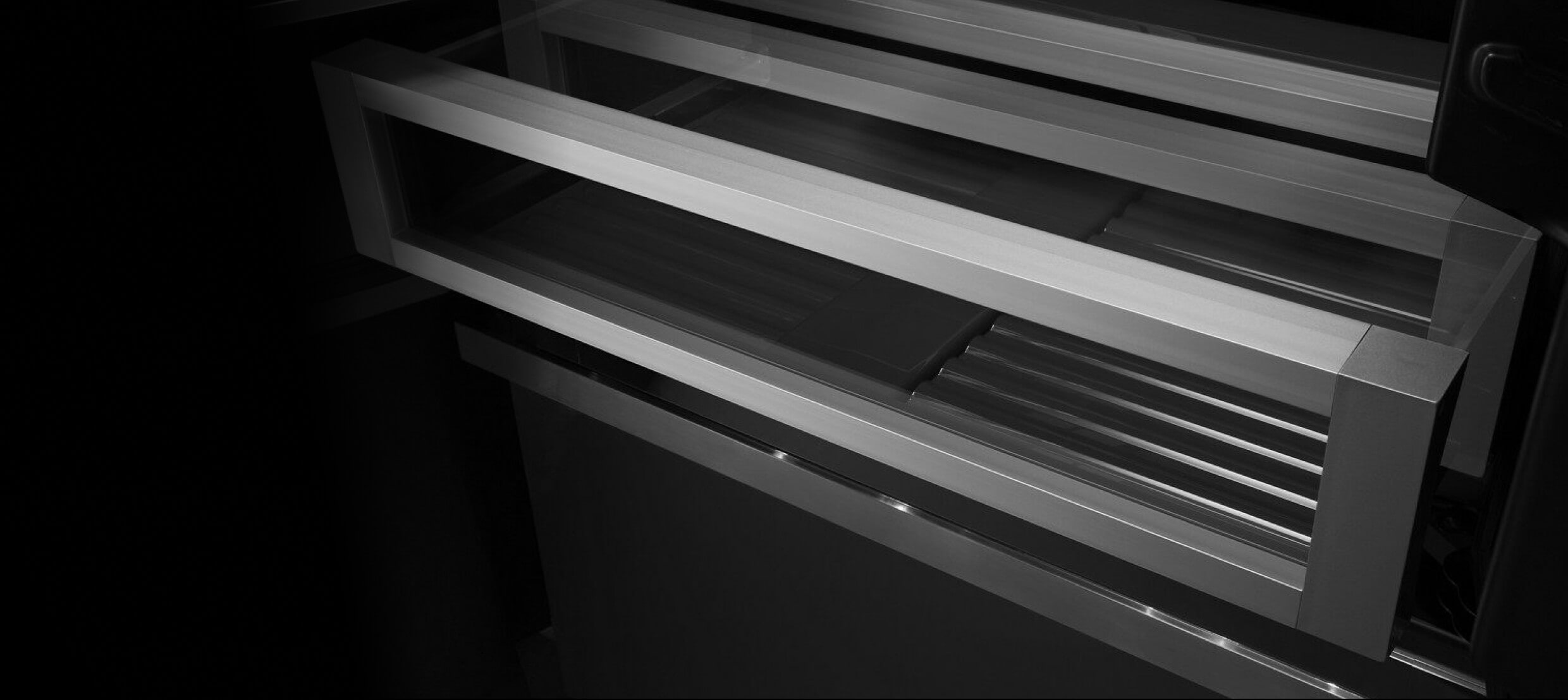  A crisper drawer in a JennAir® built-in refrigerator, slightly open.