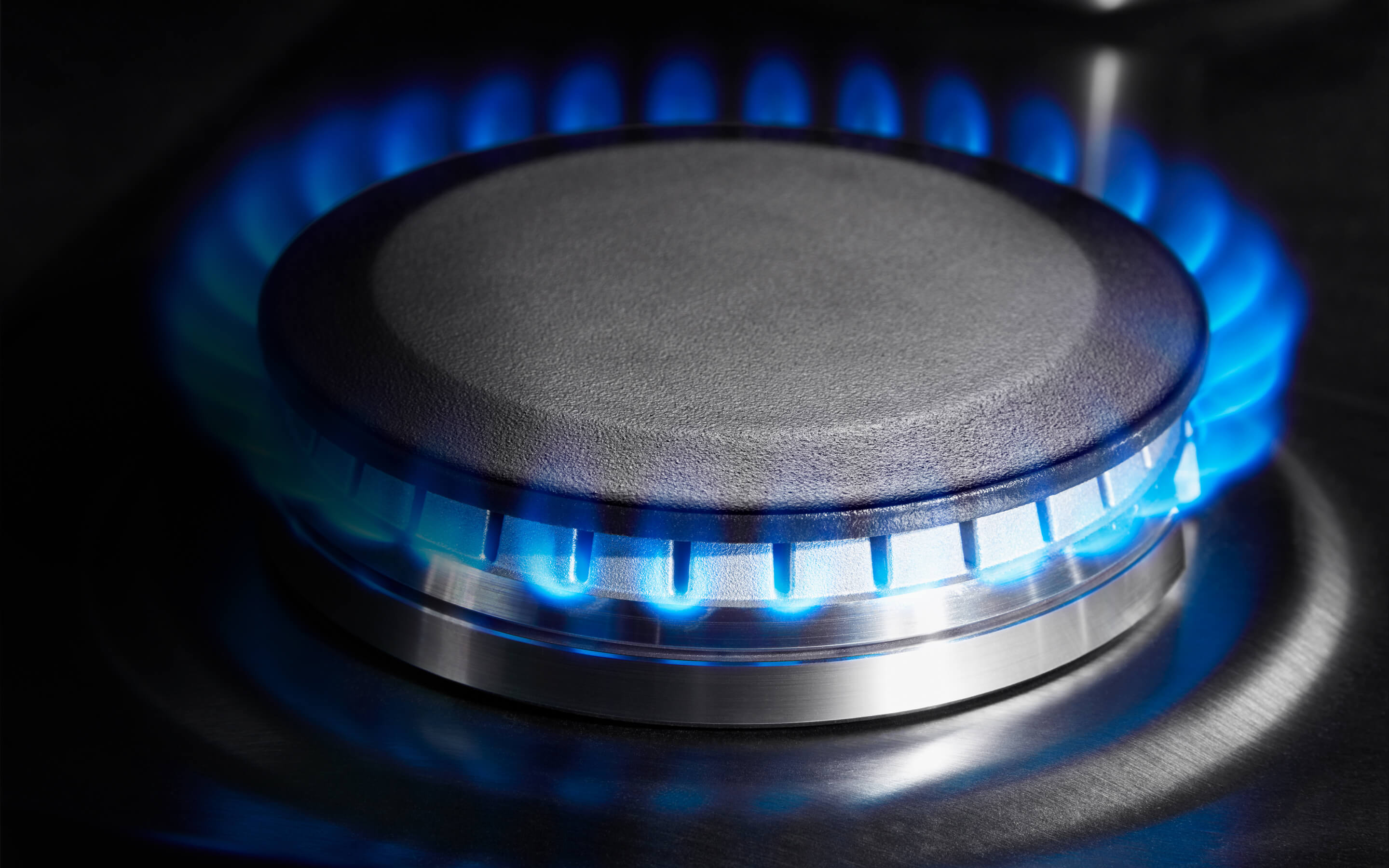 A close up of a lit burner on a slide-in range. 