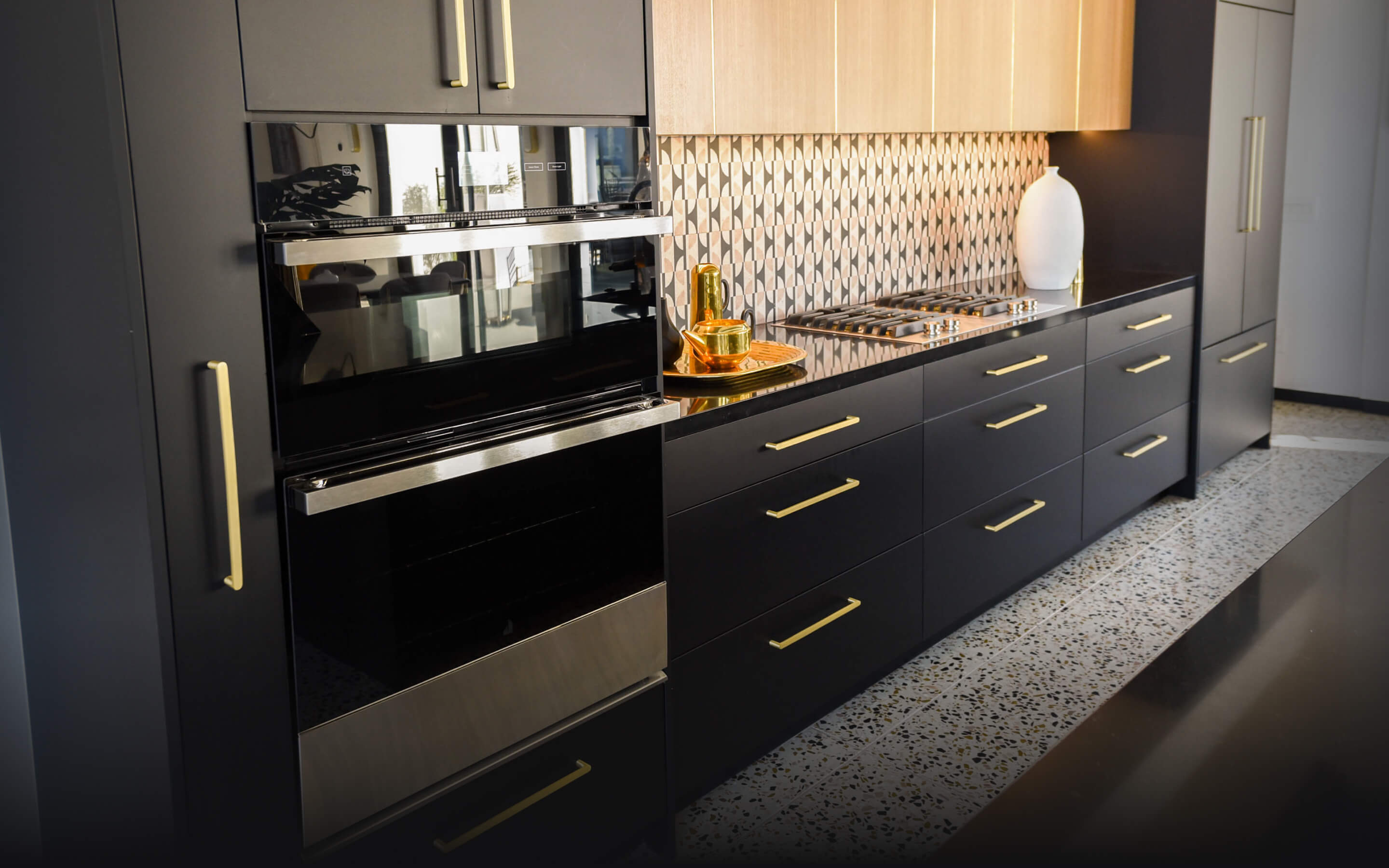 A JennAir® NOIR™ Microwave Combination Wall Oven in a modern kitchen with black cabinets. A JennAir® NOIR™ Microwave Combination Wall Oven in a modern kitchen with black cabinets.