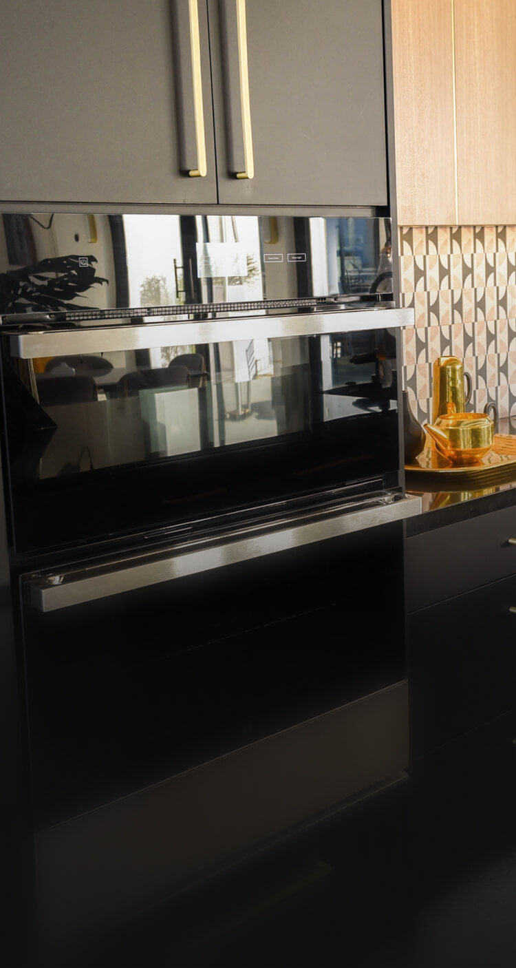 A JennAir® NOIR™ Microwave Combination Wall Oven in a modern kitchen with black cabinets. A JennAir® NOIR™ Microwave Combination Wall Oven in a modern kitchen with black cabinets.