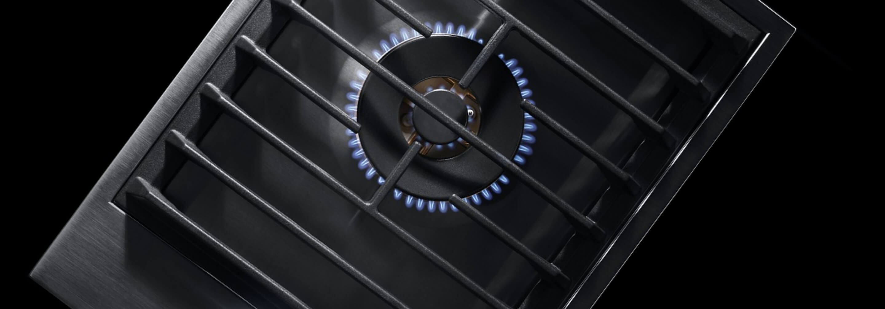 A lit 1-burner gas cooktop with wok ring.