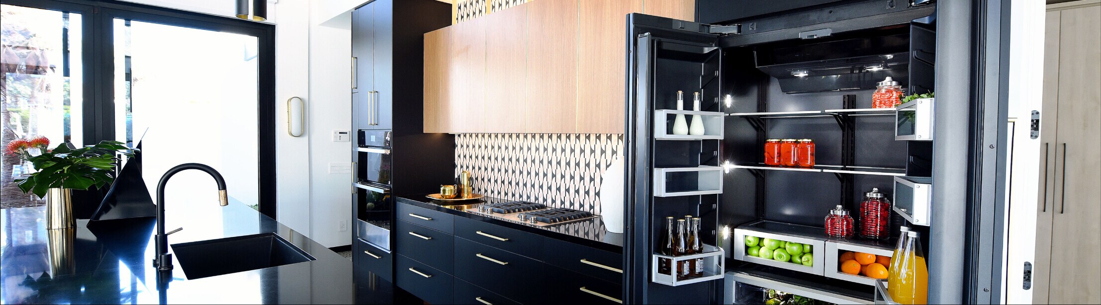 An open JennAir refrigerator in a luxe kitchen.